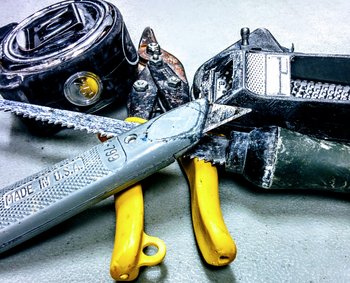 Various drywall tools including a utility knife, keyhole saw, tin-snips, measuring tape, and chalk-box