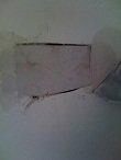 Use drywall mud to embed the mesh tape tabs. This allows the mesh tape to act securely as a hammock for the patch.